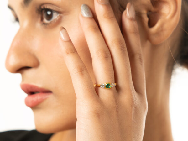 Elegant emerald ring in 18k gold, featuring a vibrant green emerald at the center, surrounded by a delicate halo of sparkling diamonds. Perfect for adding timeless sophistication to any look.