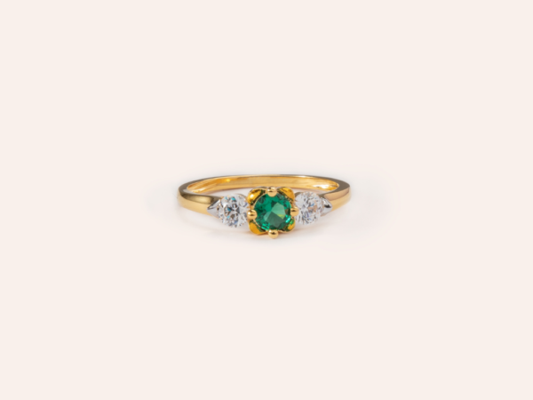 Elegant emerald ring in 18k gold, featuring a vibrant green emerald at the center, surrounded by a delicate halo of sparkling diamonds. Perfect for adding timeless sophistication to any look.