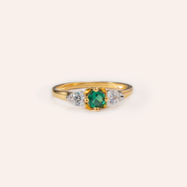 Elegant emerald ring in 18k gold, featuring a vibrant green emerald at the center, surrounded by a delicate halo of sparkling diamonds. Perfect for adding timeless sophistication to any look.